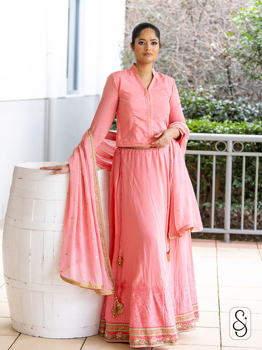 Woman in a soft pink lehenga with a 3/4 sleeve collared blouse