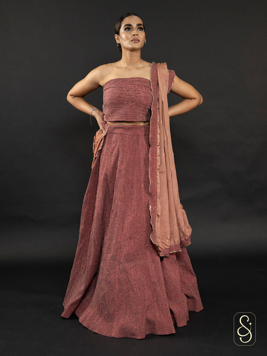 Woman wearing a crushed tissue lehenga with a strapless blouse and dupatta.