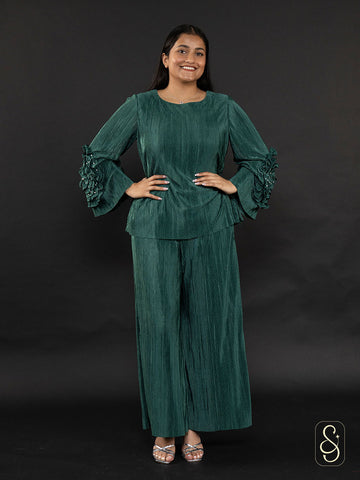 Woman wearing a green soft satin wrinkled co-ord set with ruffled sleeves.