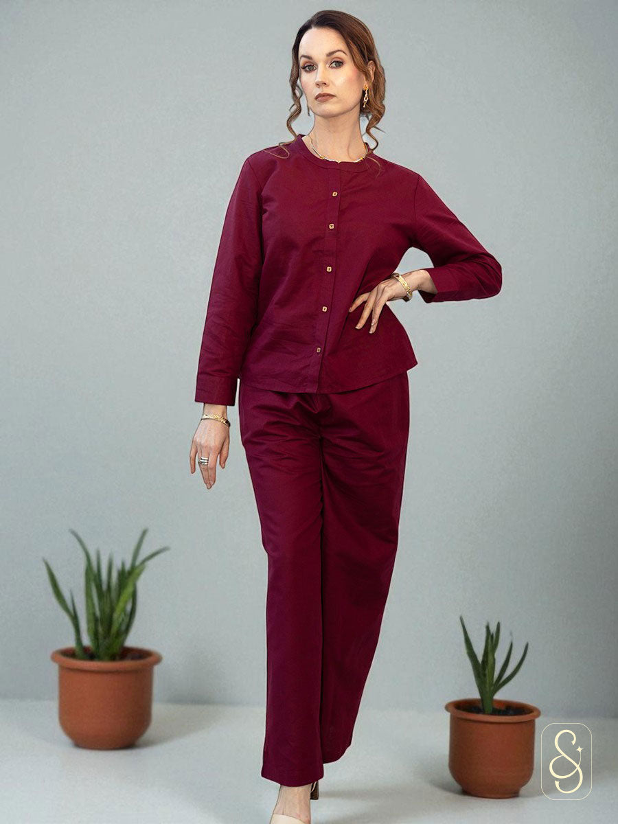 A woman wearing a solid maroon full sleeve co-ord set.