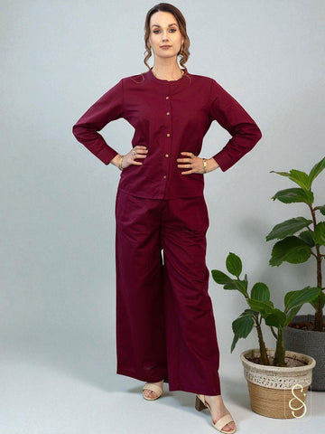 A woman posing by wearing a solid maroon full sleeve co-ord set.