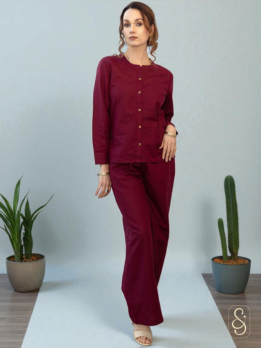A woman wearing a solid maroon full sleeve co-ord set, on a light gray background.