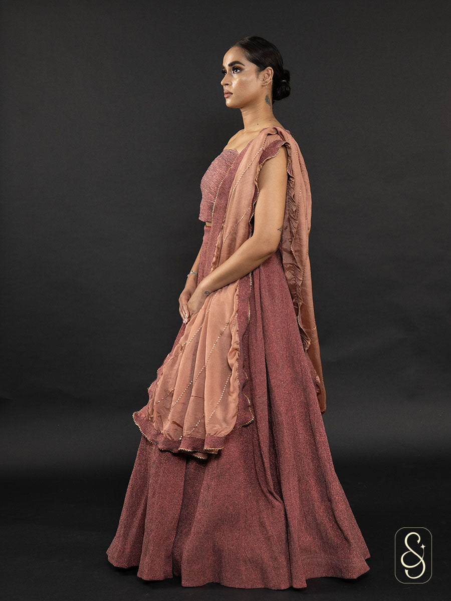 Woman wearing a crushed tissue lehenga with a strapless blouse and dupatta.