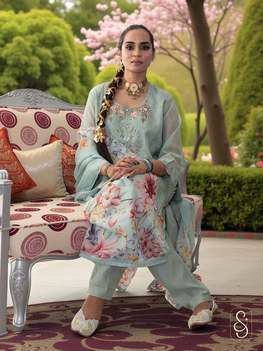 Woman in traditional suit sitting on a decorative chair.