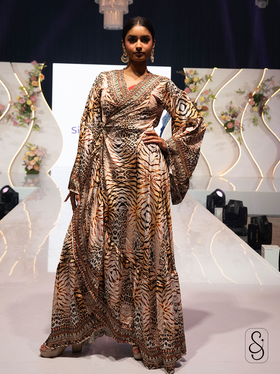 Woman in a patterned wrap dress made from smooth viscose satin posing on a stage with decorative background