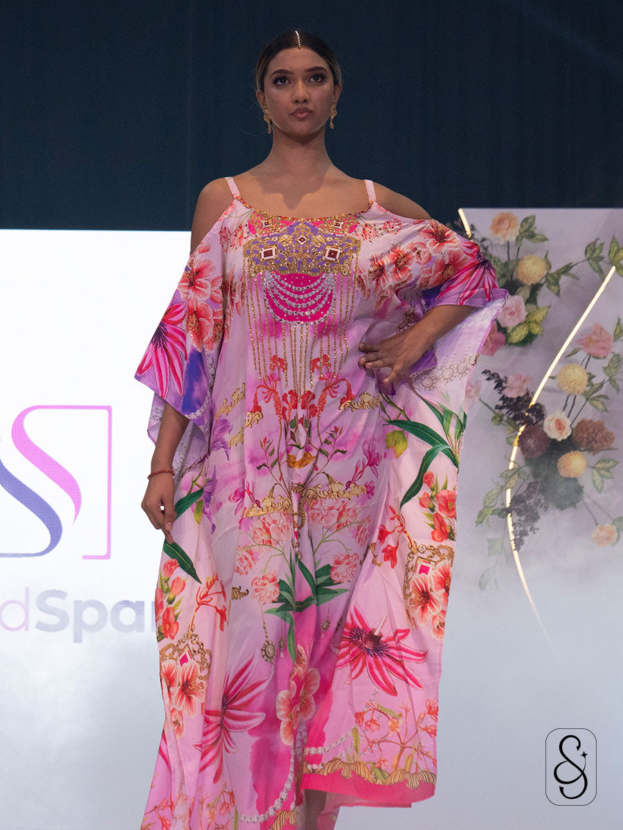 Model wearing a colourful floral kaftan on Silk and Sparkle fashion show runway.