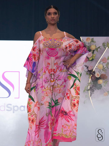 Model wearing a colourful floral kaftan on Silk and Sparkle fashion show runway.