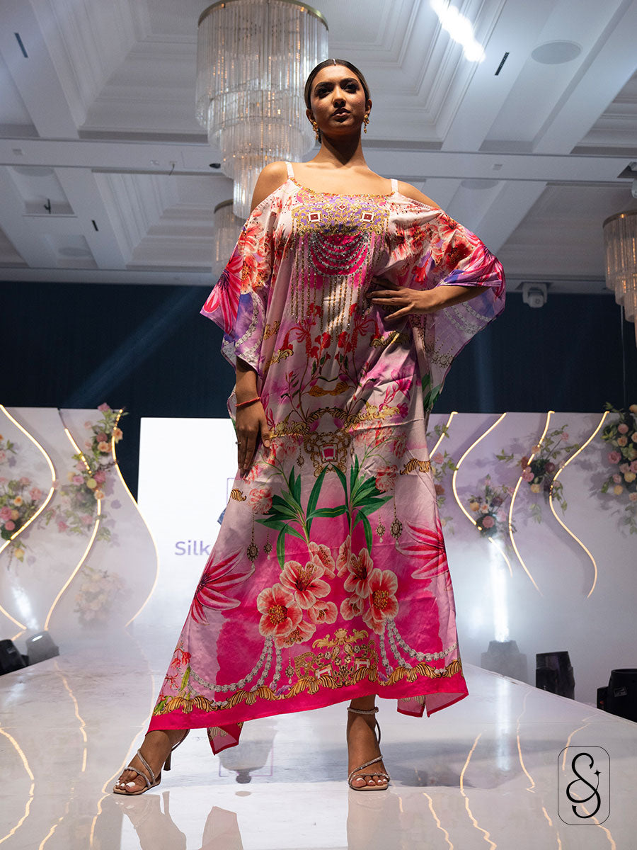 Model walking on a runway wearing colourful floral printed kaftandesigned by silk and sparkle.