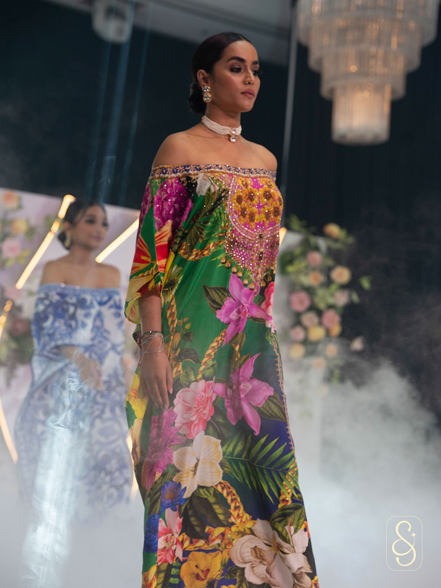 Woman in a off- shoulder colourful floral kaftan.