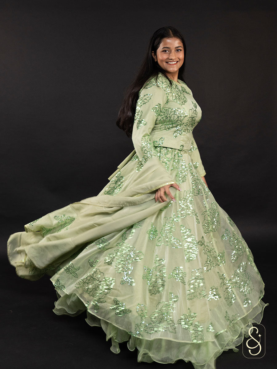 Woman wearing a light green lehenga and long sleeve blouse with sequin details