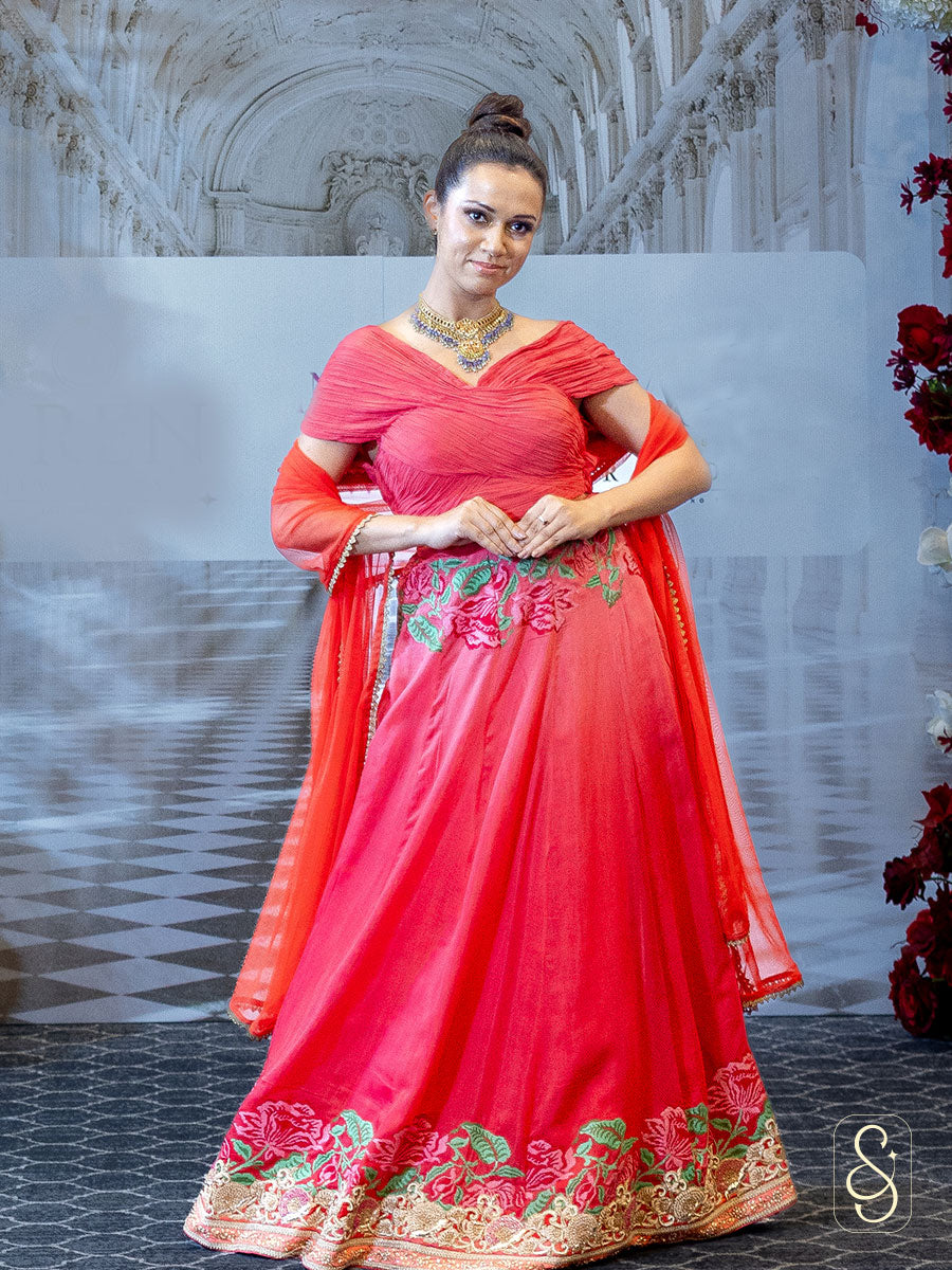 A woman in a cross stitched embroidered lehenga paired with matching blouse and dupatta. 